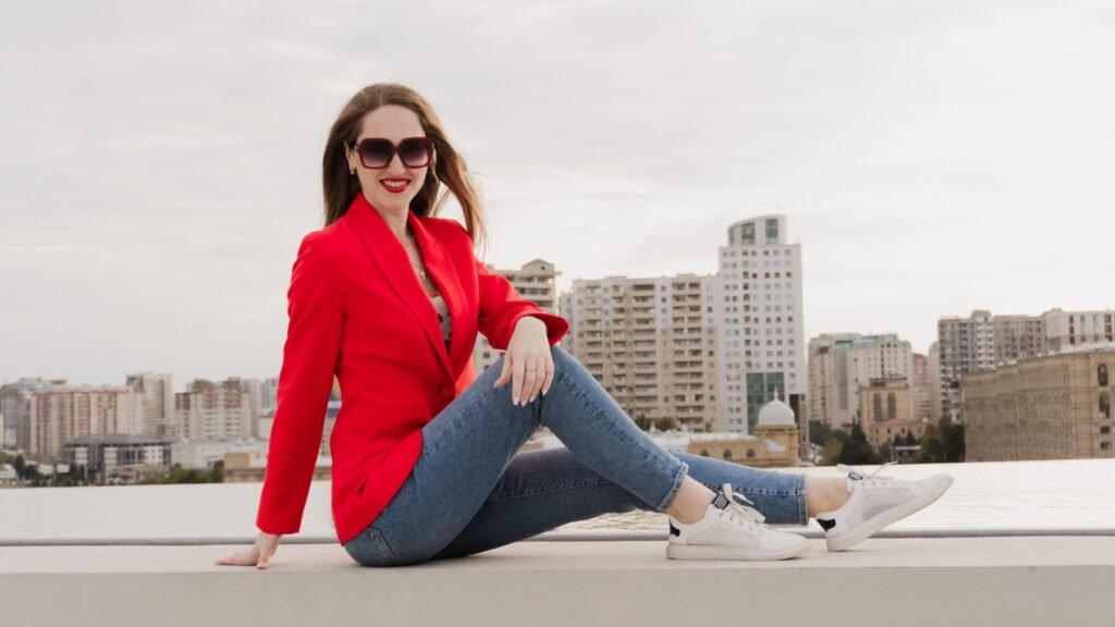 confident woman in a red blazer with a city skyline backdrop
