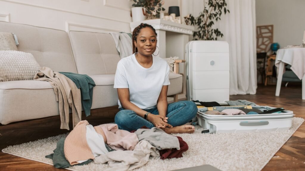 clothes spread across the floor while overpacking for a trip